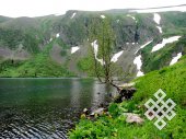 Высокогорное озеро. Прозрачная вода, нерастаявший снег, яркая зелень и красивые цветы: можно ли не восхищаться!